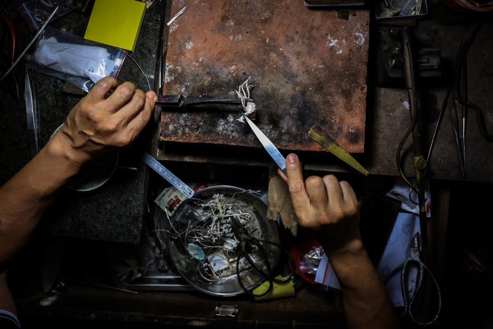 Nghệ nhân 43 tuổi trước đây không hề có ý định theo nghề của cha ông vì công việc này mất rất nhiều công sức. Người thợ bạc cần hết sức kiên trì, tỉ mỉ mới có thể hoàn thiện một sản phẩm. (Ảnh: Hoài Nam/Vietnam+)