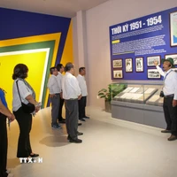 Du khách lắng nghe thuyết minh về vai trò lịch sử của Căn cứ Trung ương Cục miền Nam trong kháng chiến chống Mỹ. (Ảnh: Giang Phương/TTXVN)