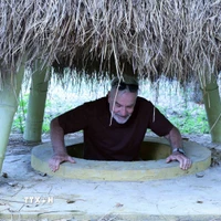 Du khách lên một cửa hầm ngay trong vườn nhà của người dân ở địa đạo Kỳ Anh. (Ảnh: Đỗ Trưởng/TTXVN)