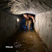 Du khách trải nghiệm đi dưới lòng địa đạo Kỳ Anh có nước ngập. (Ảnh: Đỗ Trưởng/TTXVN)