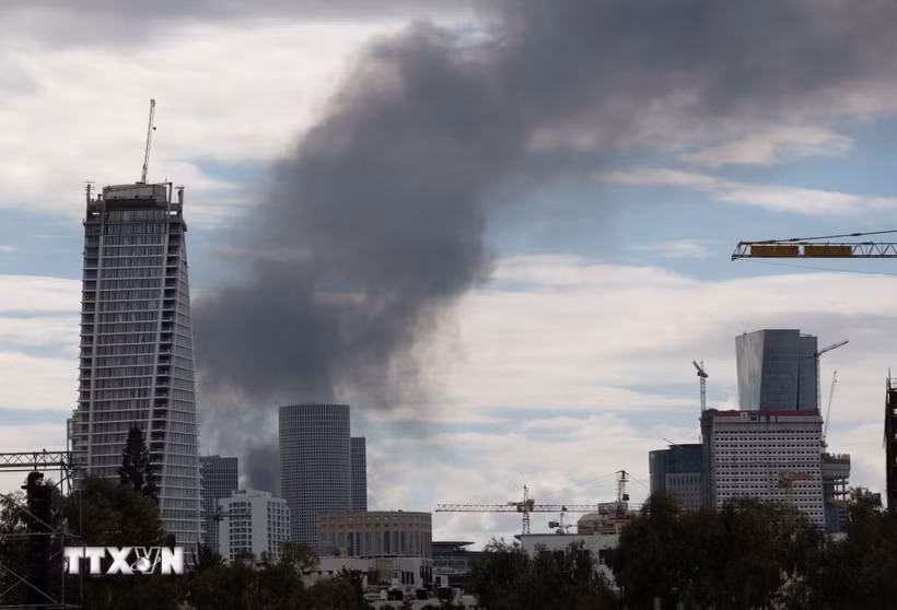 Khói bốc lên từ thành phố Tel Aviv, Israel sau cuộc tấn công đáp trả của Iran. (Ảnh: THX/TTXVN)