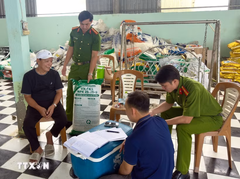 Đối tượng Hứa Văn Chọn (áo đen) làm việc với lực lượng chức năng. (Ảnh: TTXVN phát)