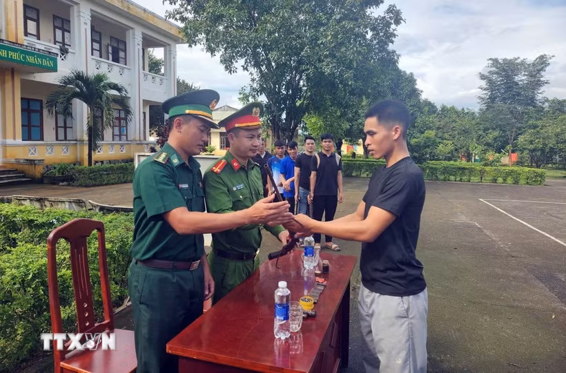 Người dân xã vùng biên Ia Đal (Quảng Ngãi) tự nguyện bàn giao súng tự chế cho đồn Biên phòng Ia Đal. (Ảnh: Cao Nguyên/TTXVN)
