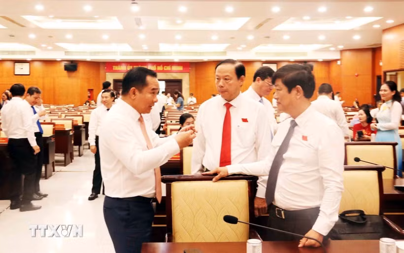 Ông Nguyễn Văn Được, Chủ tịch Ủy ban Nhân dân Thành phố Hồ Chí Minh, trao đổi với ông Võ Văn Minh, Chủ tịch Hội đồng Nhân dân Thành phố. (Ảnh: Xuân Khu/TTXVN)