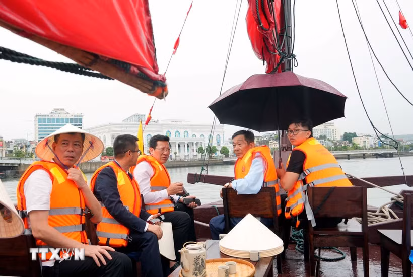 Du khách trải nghiệm với thuyền 3 vách trên vịnh Hạ Long. (Ảnh: Văn Đức/TTXVN)