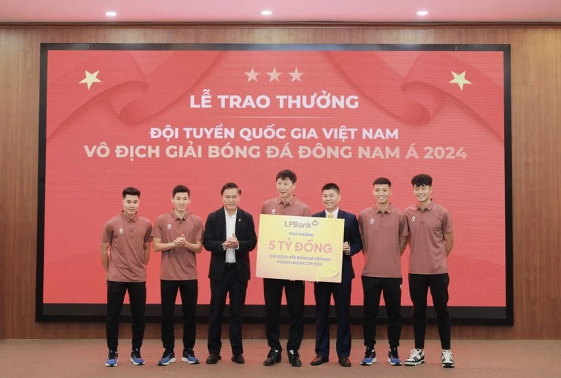 Đại diện Ngân hàng Lộc Phát Việt Nam, ông Đoàn Nguyên Ngọc, Phó Tổng Giám đốc (thứ 3 từ phải sang) trao thưởng 5 tỷ đồng cho Đội tuyển Quốc gia Việt Nam khi giành cúp vô địch ASEAN 2024. (Ảnh: Vietnam+)