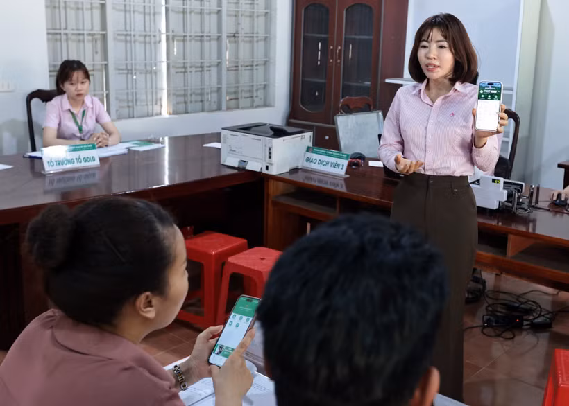 Cán bộ ngân hàng hướng dẫn người dân sử dụng ứng dụng quản lý tín dụng chính sách nâng cao. (Ảnh: Trần Việt/TTXVN)