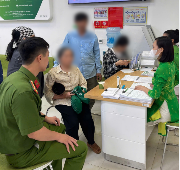 Đại diện Cơ quan công an và cán bộ Vietcombank đang giải thích và phân tích cho khách hàng. (Ảnh: Vietnam+)
