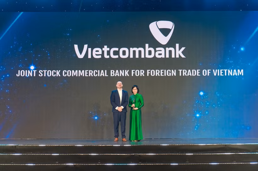 Bà Tô Thị Phương Dung - Trưởng Phòng Chính sách & Kế hoạch nhân sự đại diện Vietcombank nhận cúp "Harmonia" từ Ban tổ chức (ảnh trên) và chụp ảnh lưu niệm cùng đại diện lãnh đạo các đơn vị Vietcombank tham dự sự kiện (ảnh dưới). (Ảnh: Vietnam+)
