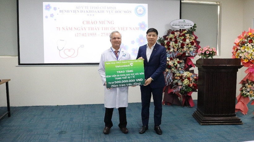Đồng chí Hồng Quang - Thành viên Hội đồng quản trị, Chủ tịch Công đoàn Vietcombank (bên phải) trao biển tượng trưng hỗ trợ 500 triệu đồng cho Bệnh viện Đa khoa Khu vực Hóc Môn. (Ảnh: Vietnam+) 