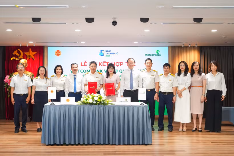 Ông Mai Sơn - Phó Cục Trưởng Cục Thuế (thứ 5, từ trái sang) và bà Đoàn Hồng Nhung - Thành viên Ban điều hành, Giám đốc Khối Bán lẻ Vietcombank (thứ 6, từ trái sang) thực hiện nghi thức ký kết và trao biên bản Thỏa thuận Hợp tác giữa Cục Thuế và Vietcombank dưới sự chứng kiến của đại diện lãnh đạo hai đơn vị. (Ảnh: Vietnam+)