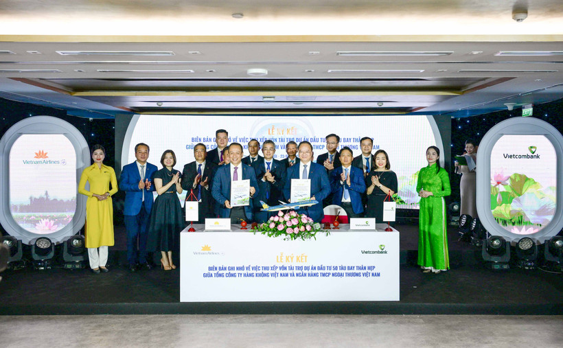 Ông Lê Quang Vinh - Thành viên Hội đồng quản trị, Tổng Giám đốc Vietcombank (bên phải) và ông Lê Hồng Hà - Thành viên Hội đồng quản trị kiêm Tổng Giám đốc Vietnam Airlines (bên trái) đại diện hai đơn vị hoàn thành nghi thức ký kết biên bản ghi nhớ trước sự chứng kiến của các đại biểu. (Ảnh: Vietnam+) 