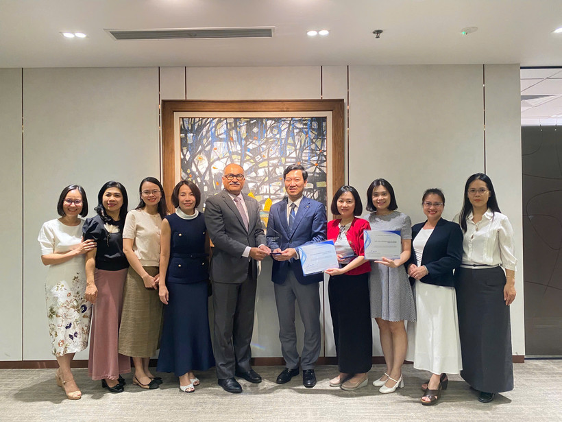 Đại diện Vietcombank, ông Vũ Quang Đông - Phó Giám đốc Khối phụ trách điều hành Khối vốn & Thị trường (đứng thứ 5 từ phải sang) nhận giải thưởng từ đại diện Ngân hàng J.P. Morgan Chase, ông Madhav Kalyan - Giám đốc Điều hành phụ trách Khối Dịch vụ thanh toán Khu vực Châu Á - Thái Bình Dương. (Ảnh: Vietnam+)