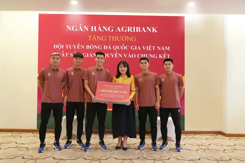 Bà Phùng Thị Bình - Phó Tổng Giám đốc Agribank trao thưởng 1 tỷ đồng cho đại diện Đội tuyển Bóng đá Quốc gia Việt Nam. (Ảnh: Vietnam+)