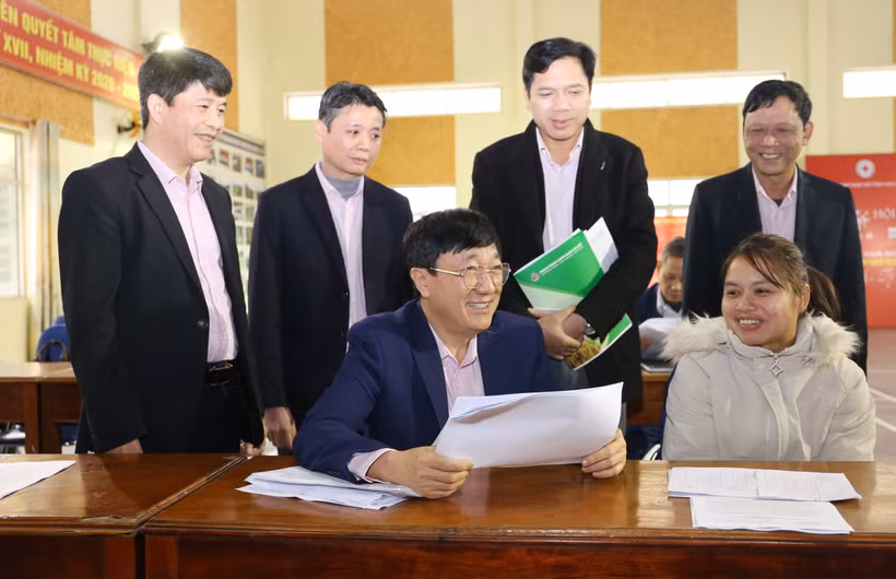 Tổng Giám đốc Ngân hàng Chính sách xã hội Dương Quyết Thắng trao đổi với Tổ trưởng Tổ tiết kiệm và vay vốn tại phiên giao dịch định kỳ hàng tháng của Ngân hàng Chính sách xã hội tại xã Phong Niên, huyện Bảo Thắng. (Ảnh: Vietnam+)