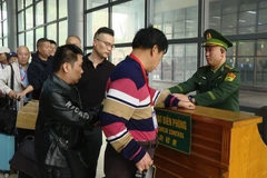 Cán bộ, chiến sĩ Bộ đội Biên phòng hướng dẫn du khách làm thủ tục xuất nhập cảnh tại Cửa khẩu quốc tế Móng Cái, Quảng Ninh. (Ảnh: PV/Vietnam+)