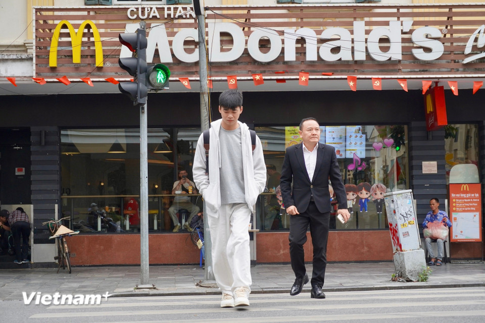 Bạn Chí Cường mặc thêm áo khoác và tận hưởng buổi sáng cuối Thu. Cười chia sẻ: "Trời mát mà đi bộ chậm chậm ngắm phố phường, tâm trí nhẹ nhàng hẳn đi." (Ảnh: Nguyễn Tâm/Vietnam+)