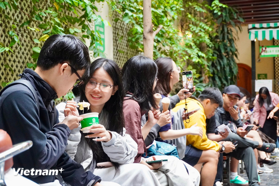 Tiết trời se lạnh mang đến cho Hà Nội buổi sáng trong lành và dễ chịu. Nhiều bạn trẻ đã tranh thủ thưởng thức từng que kem giữa phố phường Hà Nội, cảm giác lạnh thêm phần thú vị. (Ảnh: Nguyễn Tâm/Vietnam+)