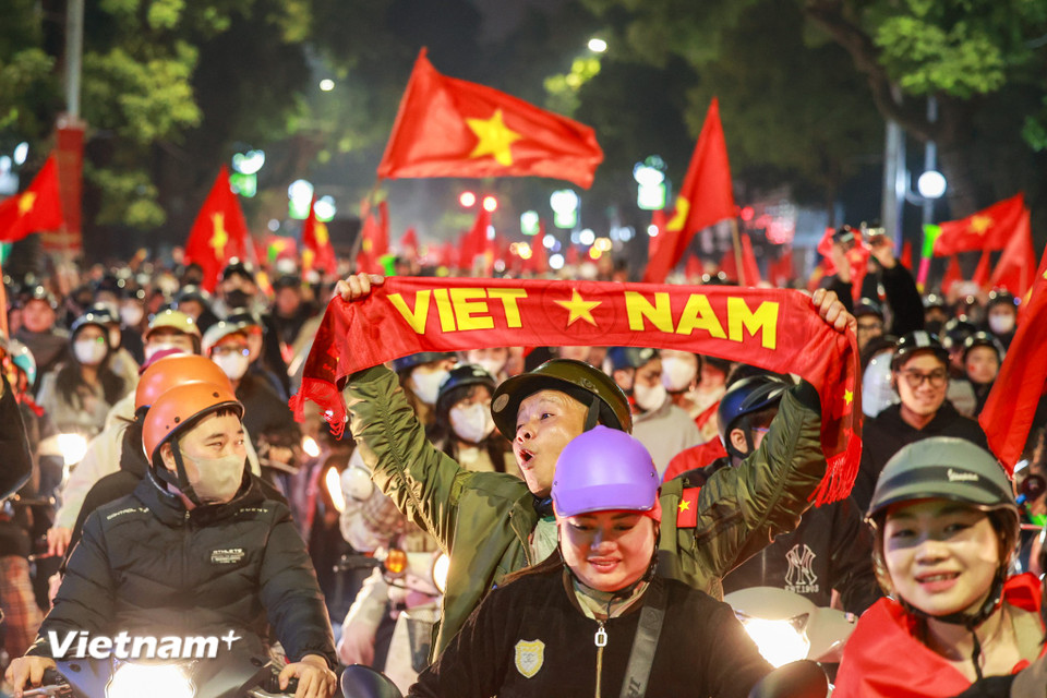 Người dân mang theo cờ đỏ sao vàng đổ về khu vực hồ Gươm ngày càng đông. Cờ Tổ quốc nhuộm đỏ nhiều con phố Hà Nội. Tiếng kèn, reo hò càng làm không khí trở nên sôi động. (Ảnh: Minh Sơn/Vietnam+)