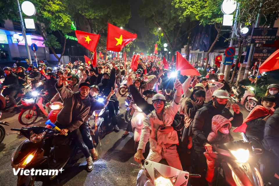 Người dân cầm theo cờ, kèn, trống đổ ra đường ăn mừng sau khi xem trận chung kết. (Ảnh: Minh Sơn/Vietnam+)