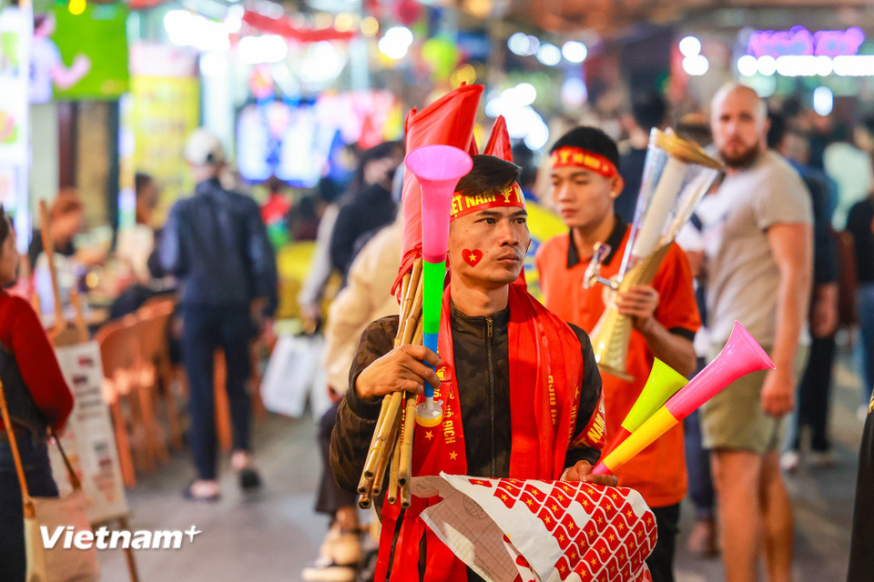 Nhiều người mang cờ, kèn để chia sẻ, cổ vũ cho đội tuyển. (Ảnh: Minh Sơn/Vietnam+)