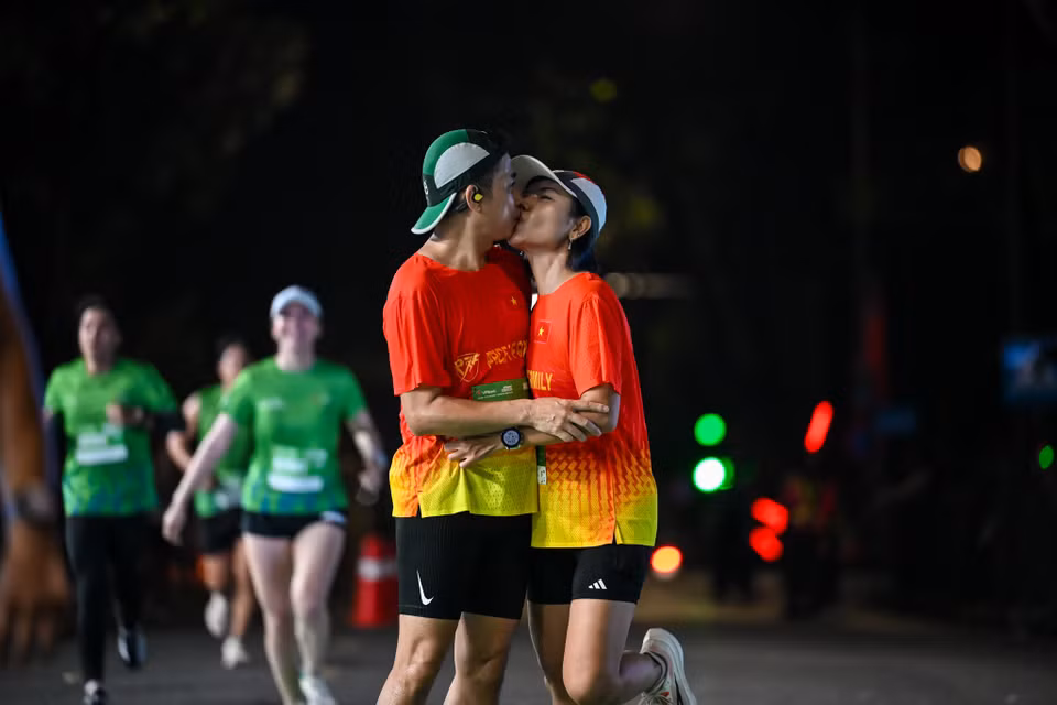 Nhiều cặp đôi trao cho nhau nụ hôn nồng nhiệt khi chinh phục đường chạy. (Ảnh: Minh Sơn/Vietnam+)