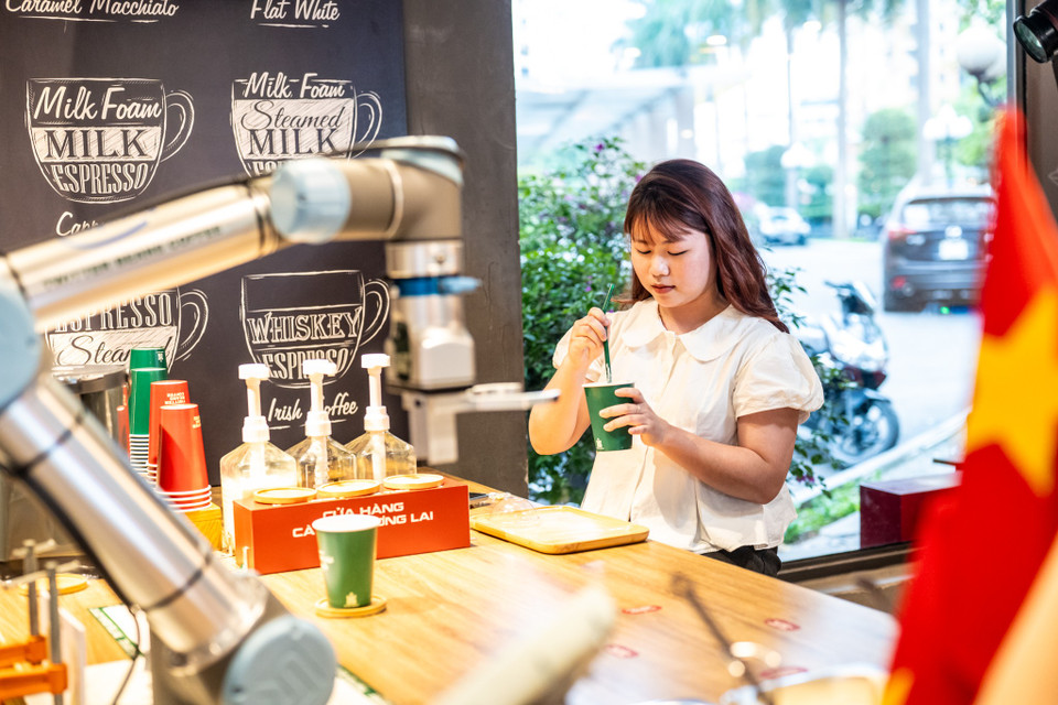 Khách đến quán sẽ được trải nghiệm một dịch vụ độc đáo khi robot được sử dụng để phục vụ những công việc như pha chế đồ uống, viết thư pháp, thậm chí chụp ảnh check-in. (Ảnh: Minh Sơn/Vietnam+)