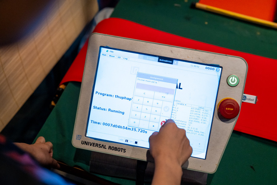 Robot viết thư pháp “Thư” mang đầy tính kết nối truyền thống. Khi khách nhập một lệnh văn bản ngắn gọn, máy sẽ dùng bút lông tạo ngay một tờ thư pháp in những câu như "Kỷ nguyên vươn mình," "Thi đâu đỗ đó" hay "Đời nở hoa." (Ảnh: Minh Sơn/Vietnam+)