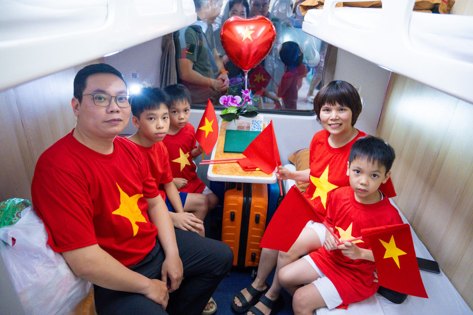 Nhiều gia đình đã mặc áo cờ đỏ sao vàng lên chuyến hành trình đầy ý nghĩa của đoàn tàu Thống Nhất. (Ảnh: Minh Sơn/Vietnam+)