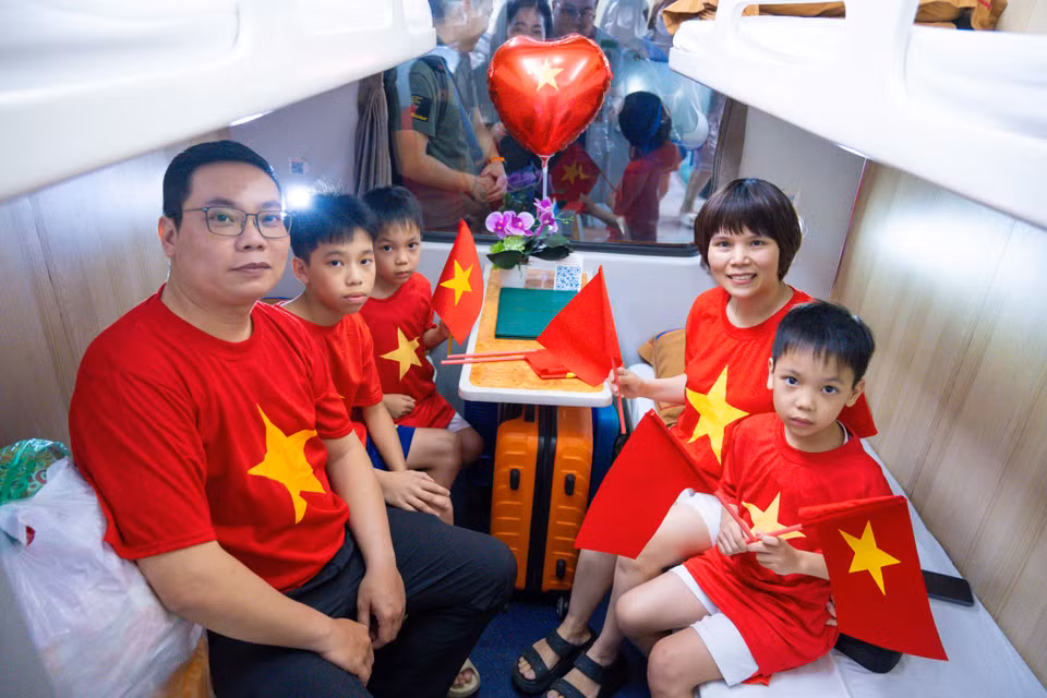 Nhiều gia đình đã mặc áo cờ đỏ sao vàng lên chuyến hành trình đầy ý nghĩa của đoàn tàu Thống Nhất. (Ảnh: Minh Sơn/Vietnam+)