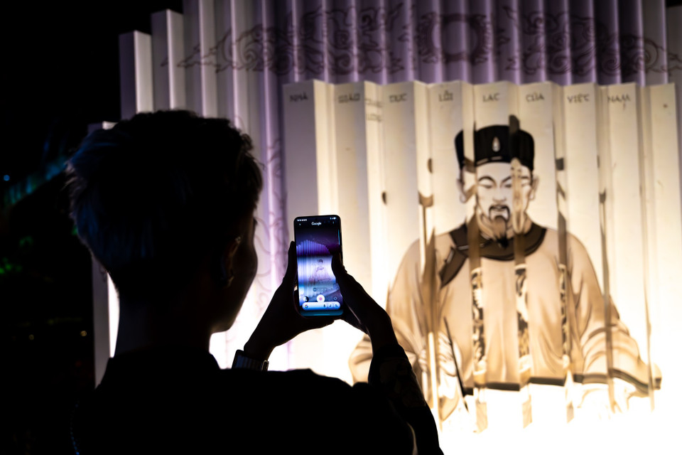 Bước vào cánh cổng Đại Trung Môn, người tham gia sẽ được khám phá cuộc sống của các thầy đồ xưa, tìm hiểu về những bậc thầy lớn của nền giáo dục Việt Nam, từ thầy Chu Văn An đến vua Lý Thánh Tông. Bằng cách chụp ảnh, AI sẽ hỗ trợ người dùng tìm kiếm thông tin về nhân vật. (Ảnh: Minh Sơn/Vietnam+)