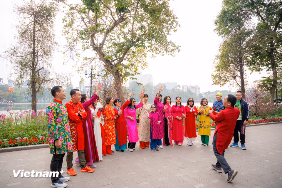 Đâu đó, những tốp người dân đã tụ tập bạn bè, người thân từ sáng sớm để đi du Xuân, chào đón một mùa Xuân tràn đầy hy vọng. (Ảnh: Minh Sơn/Vietnam+)