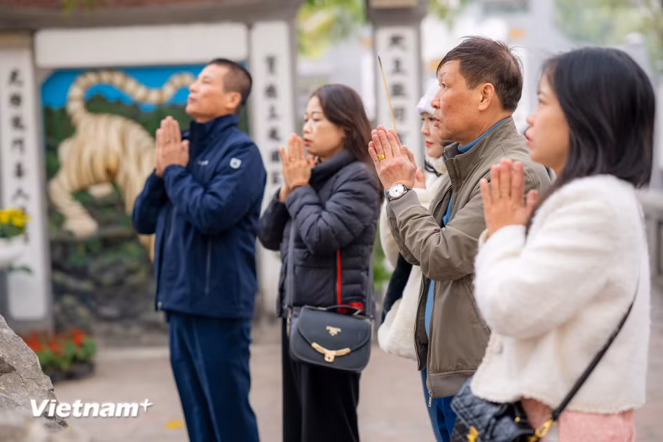 Nhiều người dân từ sớm đã đến khấn vái tại đền Ngọc Sơn, cầu mong cho một năm mới nhiều sức khoẻ, may mắn. (Ảnh: Minh Sơn/Vietnam+)