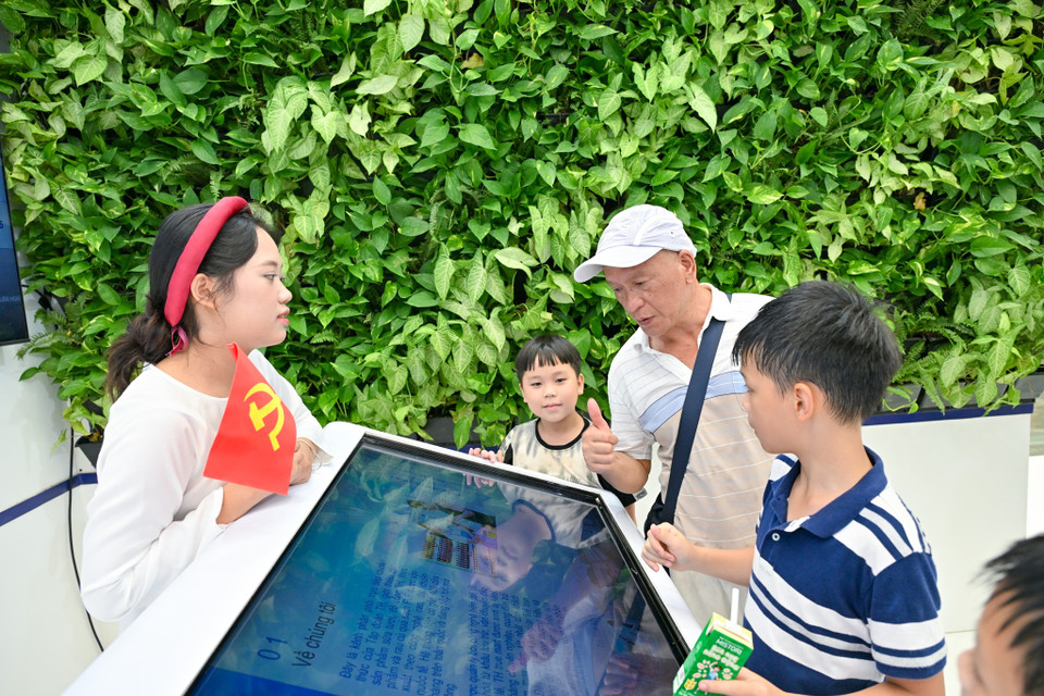 Khách tham quan xem cuốn True book của Tập đoàn TH. (Ảnh: Minh Sơn/Vietnam+)