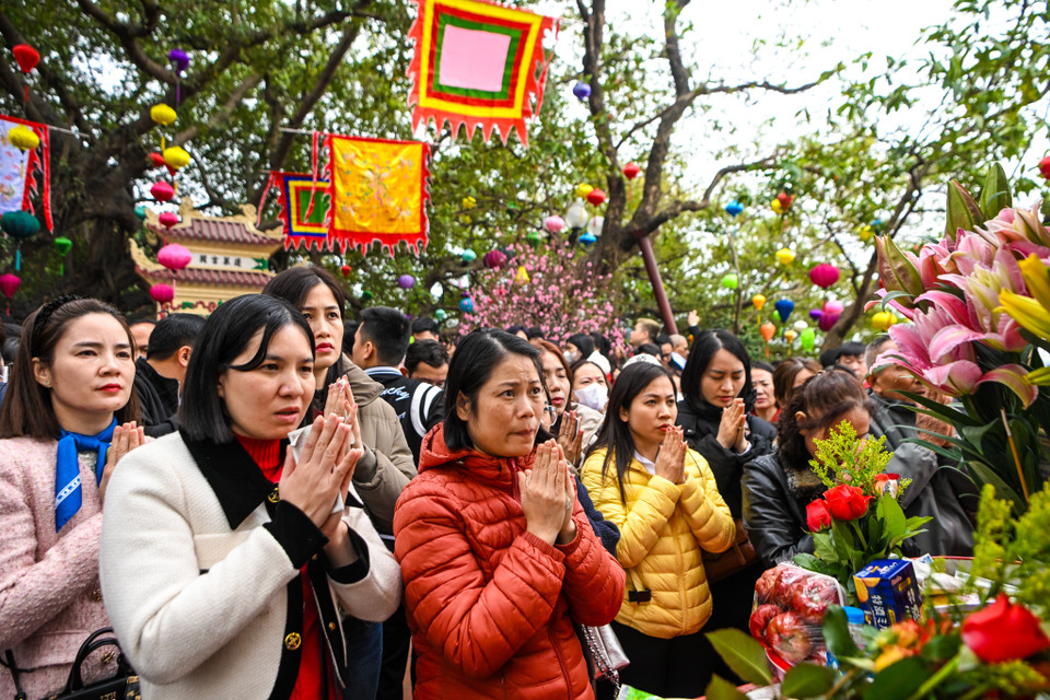 Ai nấy đều thành tâm hướng Phật, cầu mong cho mọi người trong gia đình năm mới an lành, gặp nhiều may mắn. (Ảnh: Minh Sơn/Vietnam+)