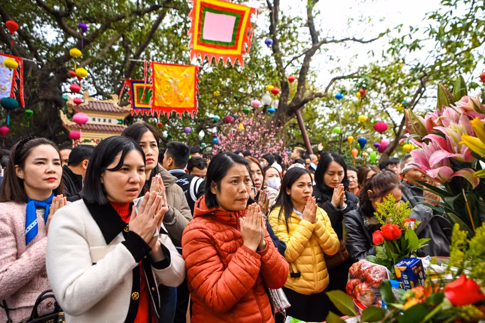 Ai nấy đều thành tâm hướng Phật, cầu mong cho mọi người trong gia đình năm mới an lành, gặp nhiều may mắn. (Ảnh: Minh Sơn/Vietnam+)