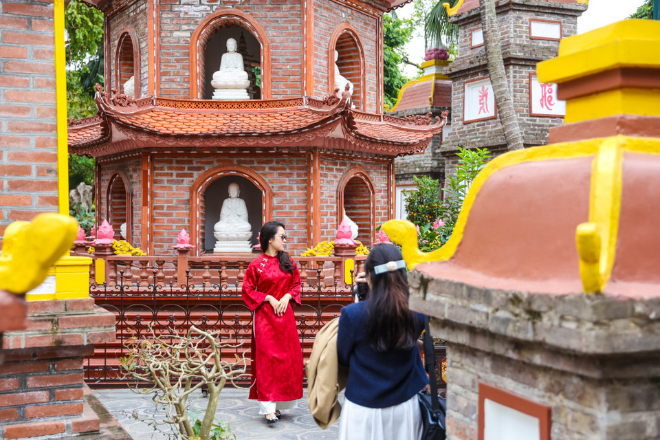 Dù thời tiết năm nay khá lạnh, nhưng trời khô ráo nên nhiều người vẫn chọn mặc áo dài đi lễ chùa, tạo nên nét đẹp thanh lịch đầu Xuân. (Ảnh: Minh Sơn/Vietnam+)