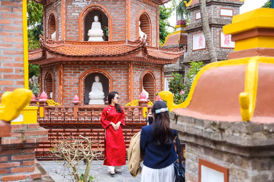 Dù thời tiết năm nay khá lạnh, nhưng trời khô ráo nên nhiều người vẫn chọn mặc áo dài đi lễ chùa, tạo nên nét đẹp thanh lịch đầu Xuân. (Ảnh: Minh Sơn/Vietnam+)