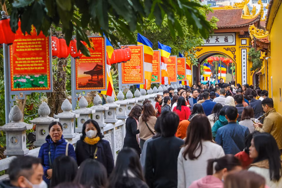 Tại chùa Trấn Quốc, một trong những ngôi chùa cổ kính và linh thiêng bậc nhất Thủ đô, hàng trăm người xếp hàng dài để vào lễ. (Ảnh: Minh Sơn/Vietnam+)