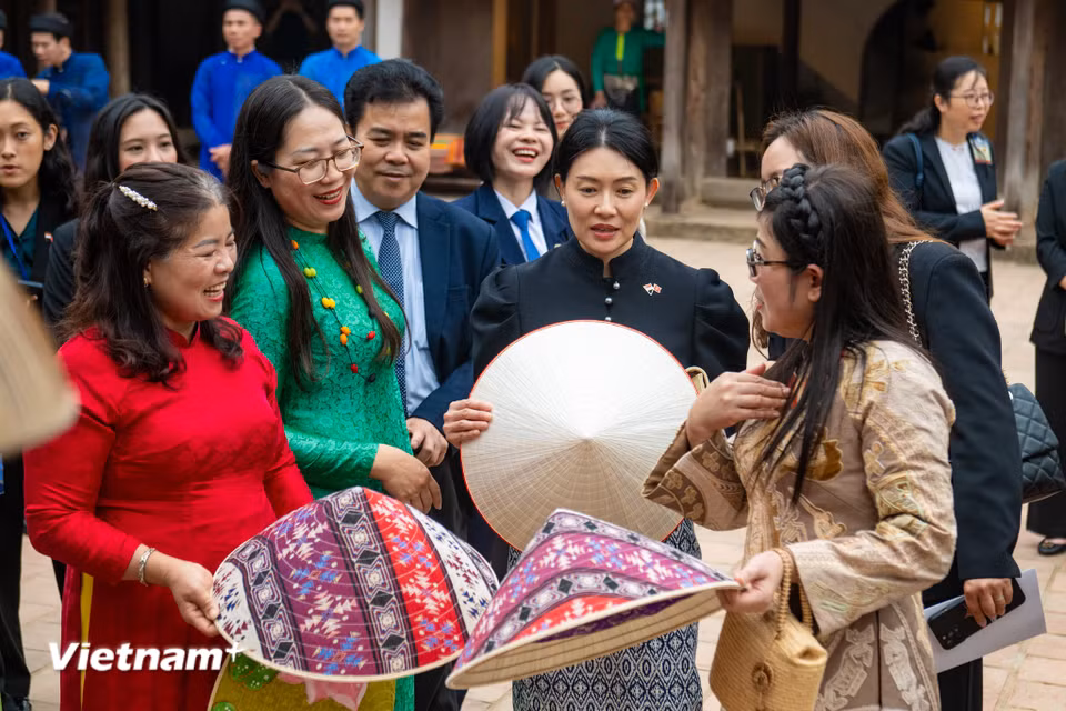 Hai Phu nhân cùng xem nghề làm nón truyền thống của làng Chuông (Hà Nội). Phu nhân Lê Thị Bích Trân đã giới thiệu với bà Loo Tze Lui về những chiếc nón lá được vẽ hình hoa sen - loài hoa đặc trưng của Việt Nam, hay chiếc nón lá vẽ thổ cẩm đầy sắc màu. (Ảnh: PV/Vietnam+)