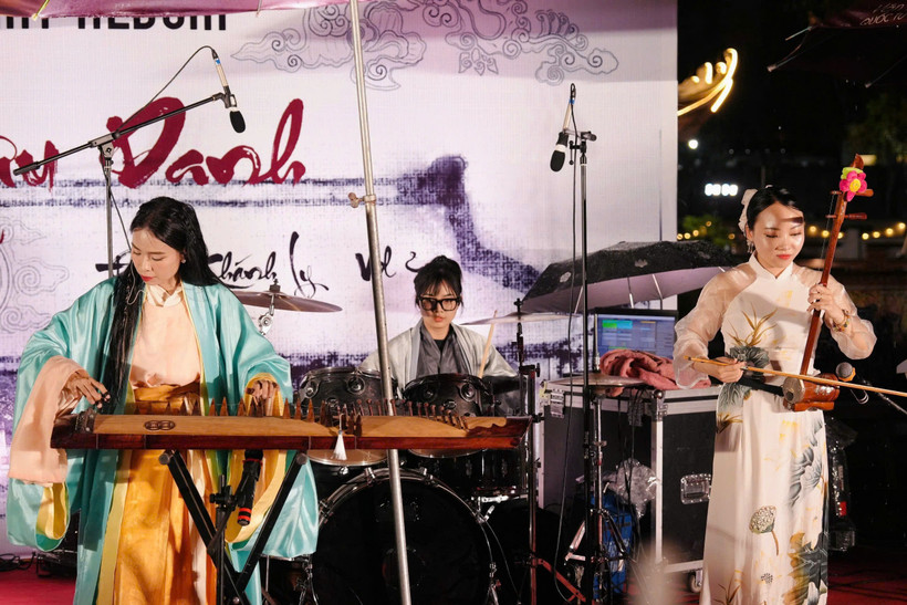 Nhạc sỹ Đinh Khánh Ly (trái) và ban nhạc biểu diễn tại Văn Miếu-Quốc Tử Giám. (Ảnh: PV/Vietnam+)