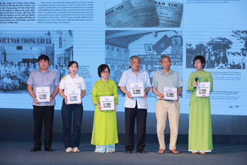 Tổng Giám đốc Thông tấn xã Việt Nam Vũ Việt Trang trao tặng cuốn sách cho các khách mời tham dự tọa đàm “Viết tiếp bản hùng ca.” (Ảnh: Hoài Nam/Vietnam+)