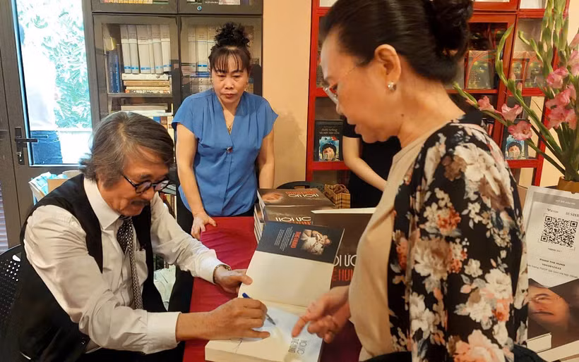 Tiến sỹ Nguyễn Thế Hùng ký tặng sách cho độc giả. (Ảnh: Minh Thu/Vietnam+)