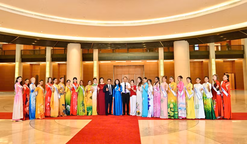 Nhà thiết kế Trinh Trinh cùng dàn thí sinh Multicultural World 2026 và ban tổ chức, giám khảo cuộc thi. (Ảnh: BTC)