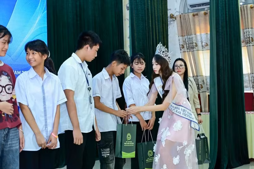 Hoa hậu Hà Linh trao những phần quà đặc biệt cho các em học sinh học giỏi có hoàn cảnh khó khăn. (Ảnh: CTV/Vietnam+)