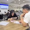 Người dân làm thủ tục về đất đai tại Trung tâm Phục vụ hành chính công Hà Nội. (Ảnh: Xuân Quảng/Vietnam+)