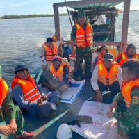 Lực lượng cứu hộ thuộc Bộ đội Biên phòng Sóc Trăng cứu nạn đưa 7 công nhân vào bờ an toàn. (Ảnh: TTXVN phát)