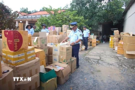 Lực lượng quản lý thị trường tỉnh Tây Ninh kiểm tra kho hàng tại hộ kinh doanh B.N. (ấp Bà Phổ, xã Thủ Thừa, tỉnh Tây Ninh) nghi giả mạo nhãn hiệu, không rõ nguồn gốc. (Ảnh: Minh Phú/TTXVN)