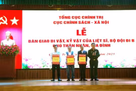 Đại tá Dương Văn Bảo, Phó Trưởng phòng Hậu phương Quân đội, Cục Chính sách-Xã hội, Tổng cục Chính trị QĐND Việt Nam, bàn giao di vật, kỷ vật của liệt sỹ về với thân nhân, gia đình liệt sỹ. (Ảnh: TTXVN phát)