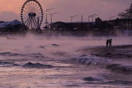 Người dân đi bộ trên bãi biển phủ đầy băng ở Michigan, Chicago ngày 23/1. (Ảnh AP)